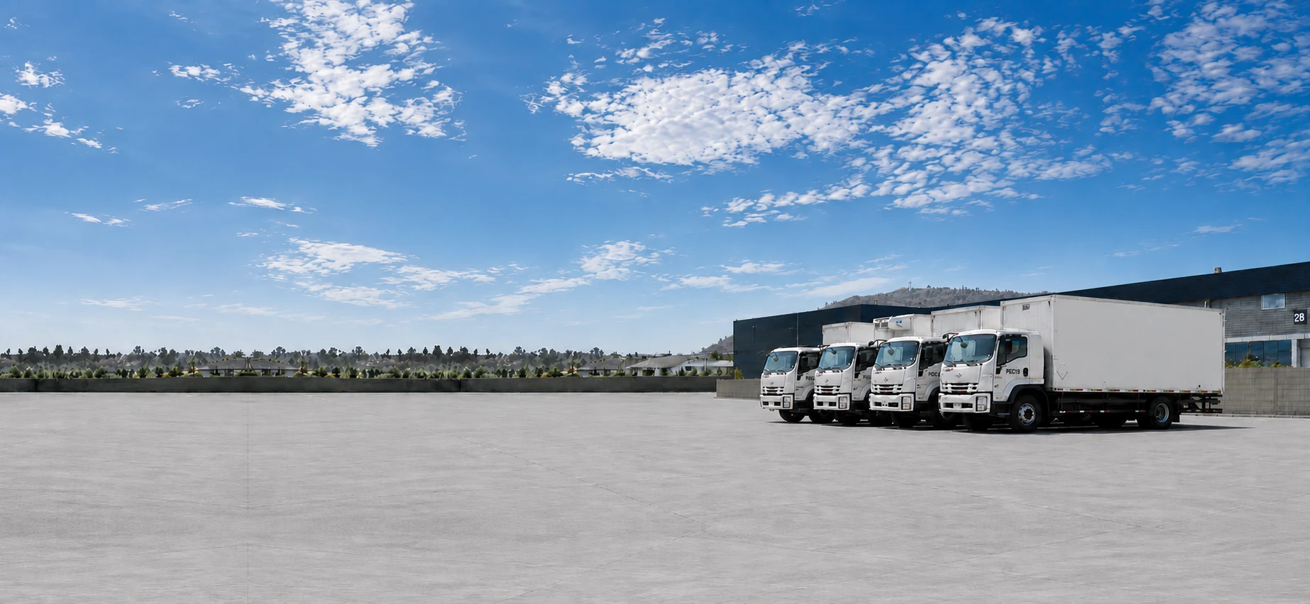 Flota de camiones de PFC Transportes estacionada frente a los andenes del centro de distribución